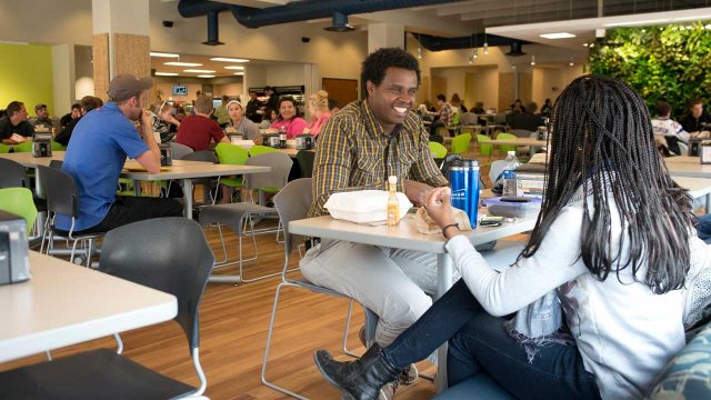 students smiling and talking while eating at Cafe 65